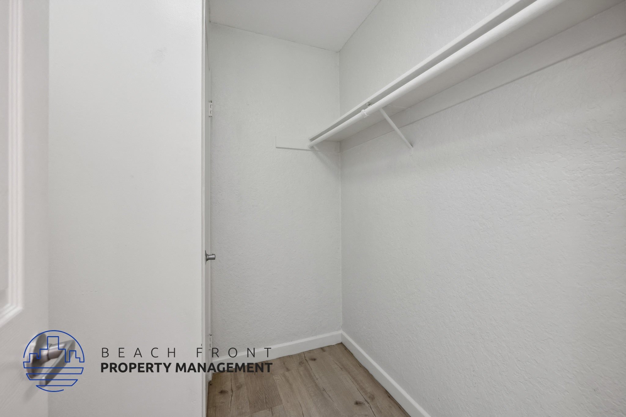 A white room with a logo for Beach Front Property Management.